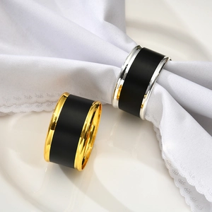 Detail of Nordic napkin rings in gold and silver finish on a white ceramic plate