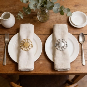 Modern hollow sun flower napkin rings in gold and silver finish on linen napkin