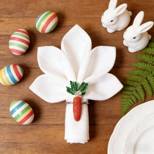 Carrot napkin ring with green leaves on white napkin for Easter table decor