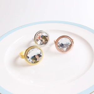 Macro detail of crystal napkin rings in gold, silver and rose gold on a ceramic plate