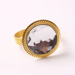 Golden napkin ring featuring a large faceted grey crystal with a textured wire base