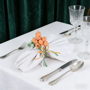 Easter napkin rings with spotted orange eggs and green leaves for festive table setting