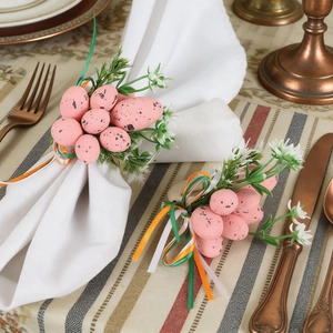 Detail of speckled Easter egg napkin rings with green leaves and colorful ribbons