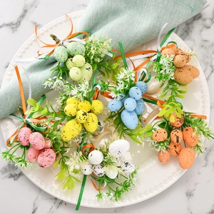 Easter spotted egg napkin rings with colorful ribbons and leaves on a ceramic plate