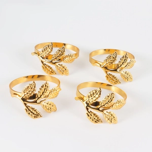 Detailed view of four golden leaf napkin rings with intricate metallic textures
