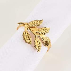 Detailed view of a gold leaf napkin ring with fine vein textures on white fabric