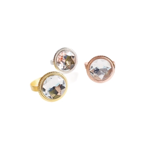 Three crystal napkin rings in gold, silver, and rose gold finishes on a white background