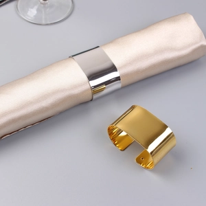 Modern C-shaped gold and silver metal napkin rings with a polished mirror finish