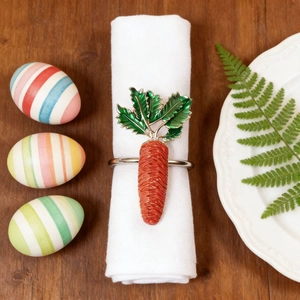 Carrot napkin ring with green leaves on white linen over a wooden table setting