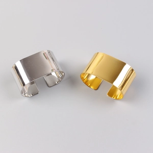 Detail view of C-shaped metal napkin rings in gold and silver with mirror finish