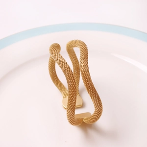 Macro shot of gold woven mesh napkin ring with a stylish wave design and metal texture