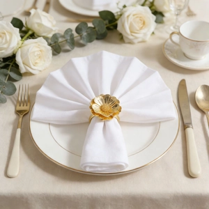 Elegant gold flower napkin ring on white linen napkin for luxury table setting decoration