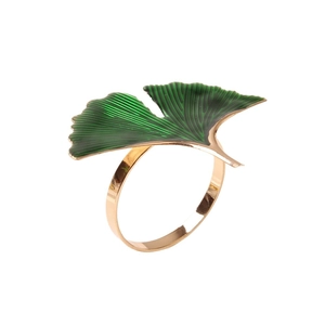 Golden ginkgo leaf napkin ring with green enamel finish on a white background