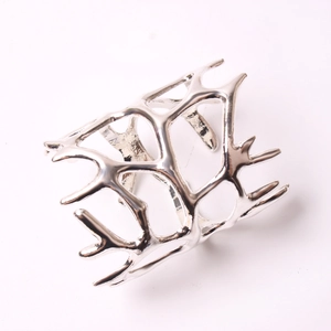 Macro shot of silver coral branch napkin ring with intricate hollow metallic texture