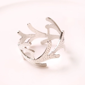 Macro shot of silver coral branch napkin ring with textured branch design on white base