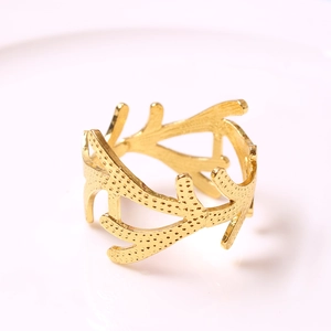 Macro view of gold coral napkin ring featuring textured branch design and hollow structure