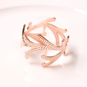 Elegant gold coral napkin ring featuring detailed branch textures on a white surface
