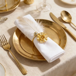 Elegant gold flower napkin ring with bead accent on a white linen napkin and plate