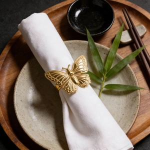 Eleganter goldener Schmetterling Serviettenring auf weißem Tuch mit Gedeck im Asia-Stil