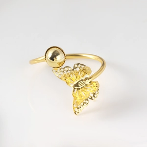 Detailed macro of golden metal napkin ring with hollow butterfly and sphere design
