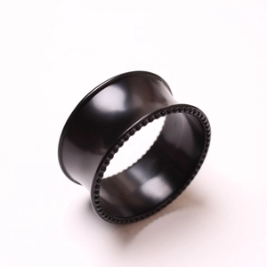 Vista macro de túnel de oreja negro pulido con borde perlado para piercing de oreja