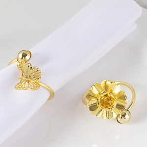 Detail of elegant gold double-layer butterfly and flower metal napkin rings for wedding decor