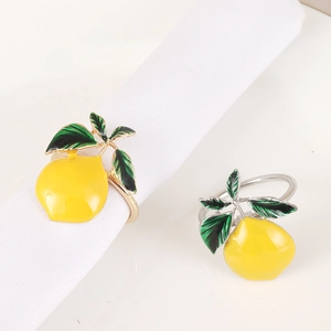 Detailed macro view of metal lemon napkin rings with vibrant yellow enamel finish