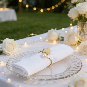 Golden star napkin ring with pearl on white napkin for elegant table setting