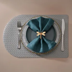 Rond de serviette libellule dorée avec ailes texturées sur serviette en lin bleu