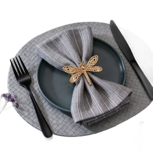 Détail macro du rond de serviette libellule dorée aux ailes évidées avec élégance