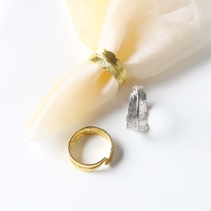 Macro view of gold and silver feather napkin rings with detailed metal texture