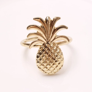 Golden pineapple napkin ring with intricate mesh texture for creative table decor