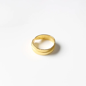 Macro detail of golden feather leaf napkin ring with intricate textured adjustable design