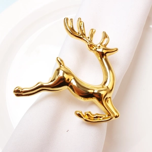 Polished gold elk napkin ring on white linen napkin for Christmas table decoration