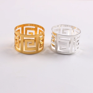 Detail showing gold and silver napkin rings with meander Greek key hollow patterns