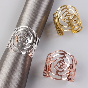 Detailed macro view showing three-color hollow rose napkin rings in gold, silver and rose gold