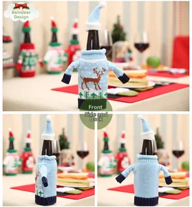 Blue knitted Christmas wine bottle cover with reindeer and forest patterns and pompom hat