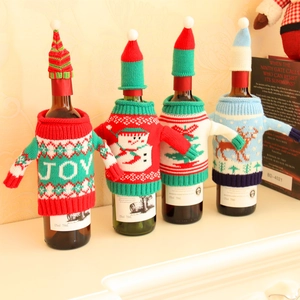 Detailed view of four festive knitted Christmas wine bottle covers with holiday patterns