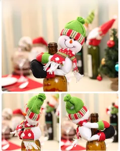 Detail of Christmas snowman wine bottle cover with green knitted hat and striped scarf