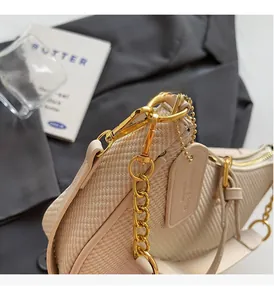 Detail of cream woven handbag with luxury gold chain hardware and smooth leather tag