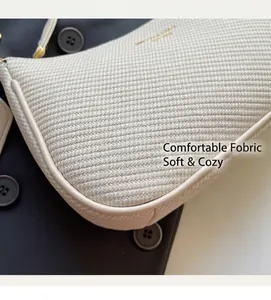 Detail of cream woven shoulder bag featuring herringbone fabric and leather trim edges
