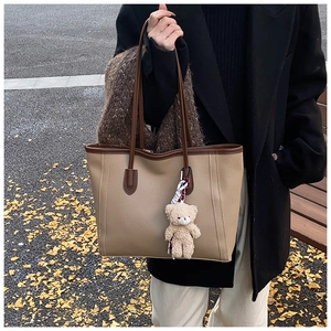 Dettaglio della borsa tote vintage in pelle martellata con ciondolo a orsetto