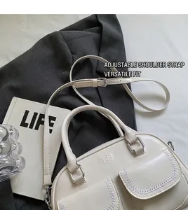 Cream white shoulder bag detail with woven stitching front pockets and silver hardware