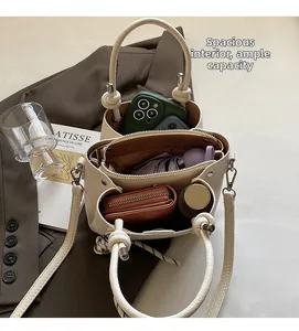 Litchi texture bucket bag interior showing phone, wallet, bottle and umbrella storage