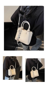 Detail of cream leather tote with braided knot pendant and detachable shoulder strap