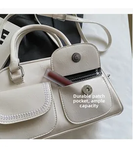 Detail of beige faux leather bag showing practical magnetic front pockets with stitching