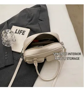Detail view of cream crossbody bag interior space and textured leather surface