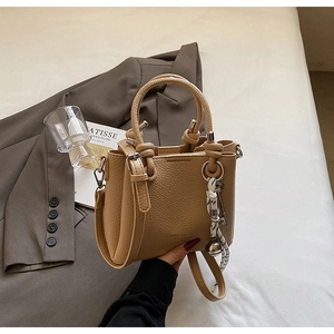 Détail du sac seau en cuir grainé marron clair avec pendentif en corde tressée