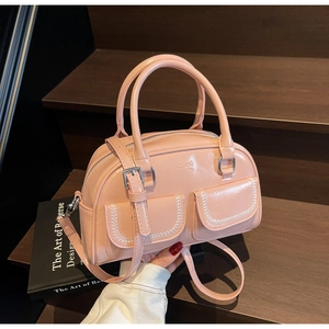 Pink matte leather crossbody bag featuring dual front pockets and silver hardware detail