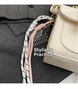 Dettaglio del cordino intrecciato con mini racchetta da tennis e ciondoli sulla borsa